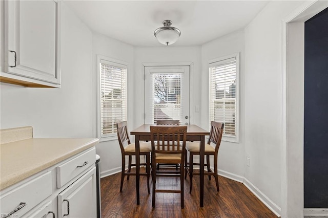 dining room with plenty of natural light, baseboards, and dark wood-style flooring