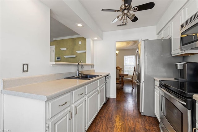 kitchen featuring a sink, dark wood-type flooring, white cabinets, light countertops, and appliances with stainless steel finishes