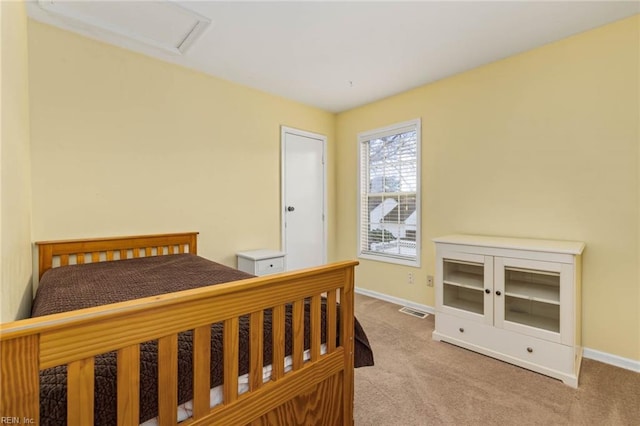 bedroom featuring visible vents, attic access, baseboards, and carpet