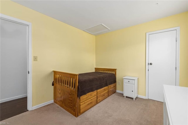 bedroom featuring attic access, baseboards, and light carpet