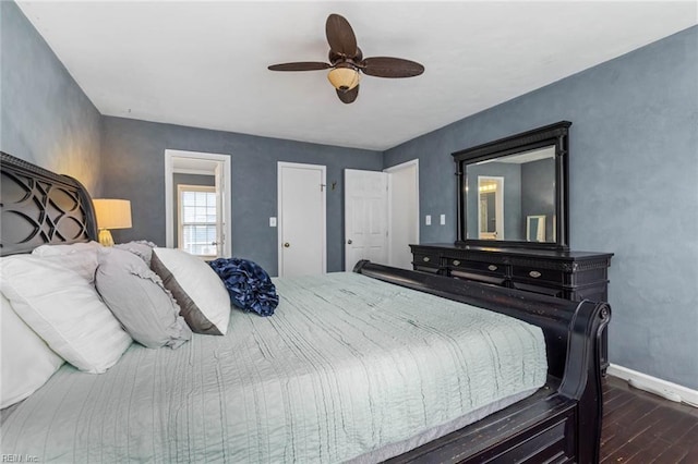 bedroom with a ceiling fan, dark wood-type flooring, and baseboards