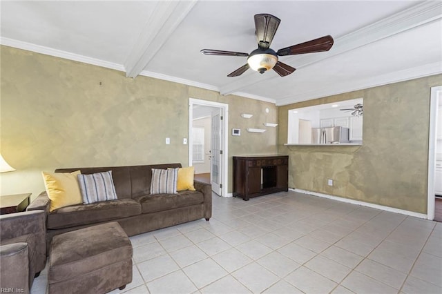 living room with ceiling fan, baseboards, beamed ceiling, ornamental molding, and light tile patterned flooring