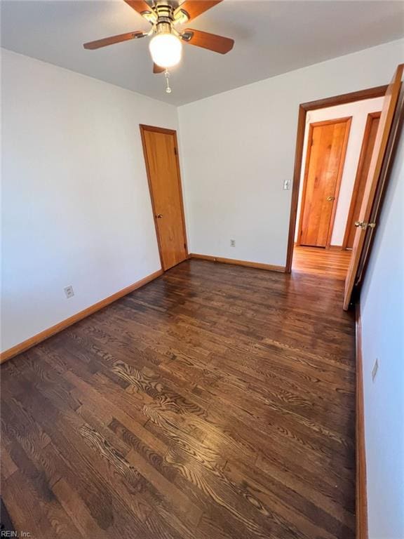 empty room featuring ceiling fan, baseboards, and wood finished floors