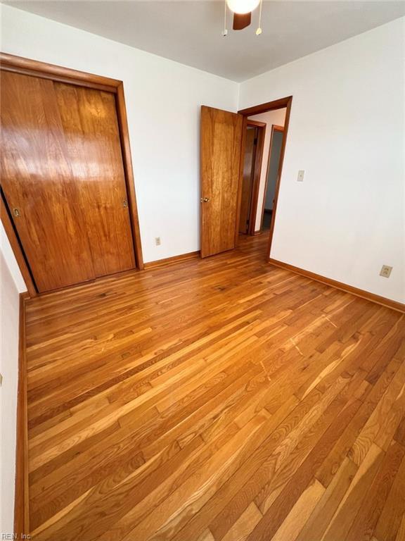 unfurnished bedroom with a closet, baseboards, and light wood finished floors