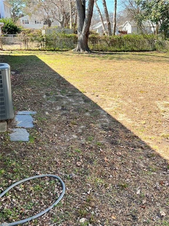 view of yard featuring central AC unit and fence