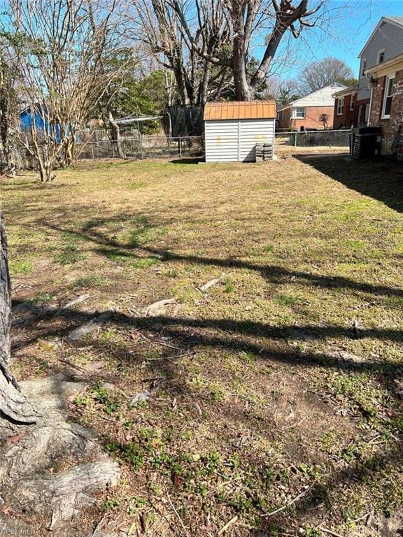 view of yard featuring an outdoor structure, a storage unit, and a fenced backyard