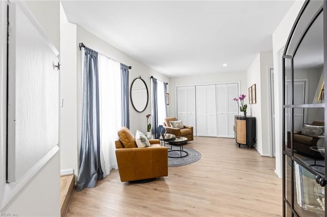 living area with recessed lighting and light wood finished floors