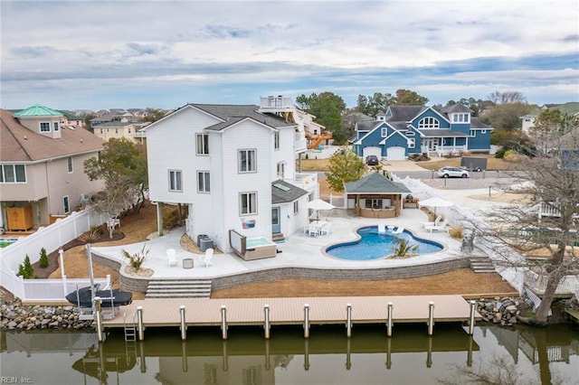 rear view of property with a patio, a fenced backyard, a residential view, and a water view