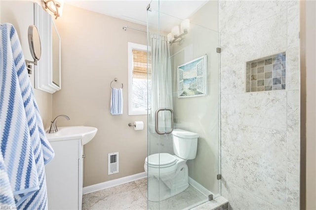 full bath with visible vents, toilet, a stall shower, baseboards, and vanity