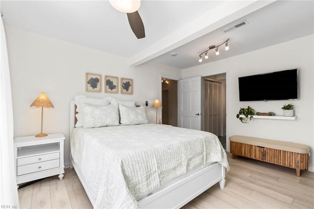 bedroom featuring wood finished floors, visible vents, a closet, and ceiling fan