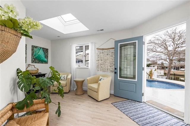 doorway with a skylight and wood finished floors