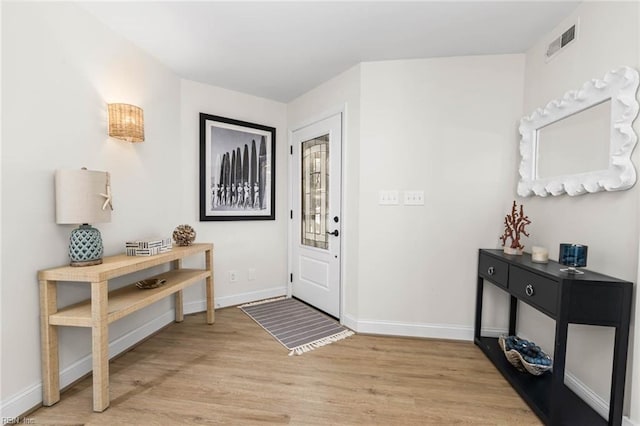 foyer with visible vents, baseboards, and light wood-style flooring