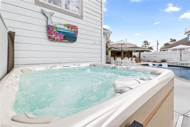 exterior space featuring a jacuzzi and fence