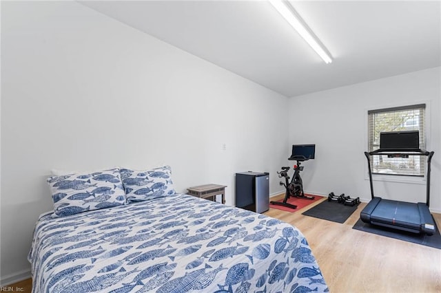 bedroom with baseboards and wood finished floors