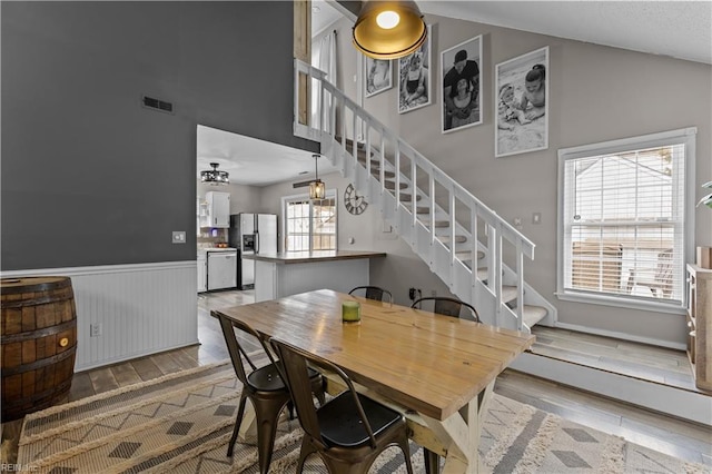 dining room featuring stairs, wood finished floors, visible vents, and wainscoting