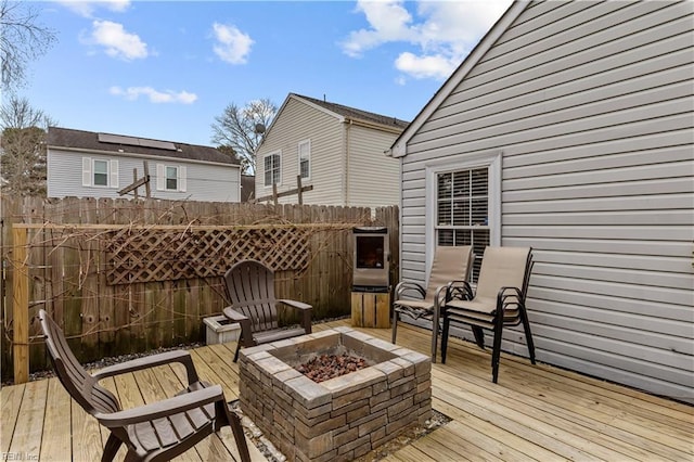 wooden deck with an outdoor fire pit and fence