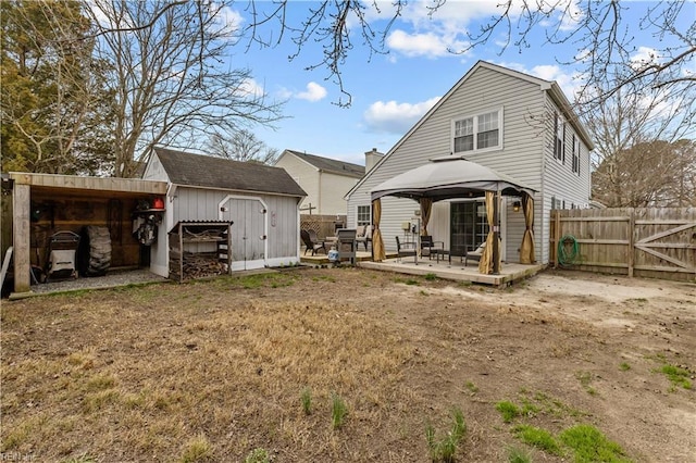 back of house with a gazebo, an outbuilding, fence, and a shed