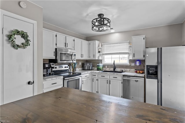 kitchen featuring a sink, open shelves, appliances with stainless steel finishes, white cabinets, and decorative backsplash