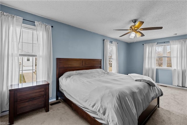 bedroom featuring a textured ceiling, ceiling fan, and carpet floors