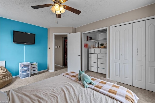 bedroom with multiple closets, a textured ceiling, carpet flooring, baseboards, and ceiling fan