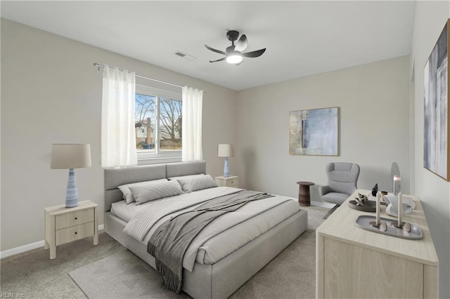 bedroom with a ceiling fan, baseboards, visible vents, and light carpet