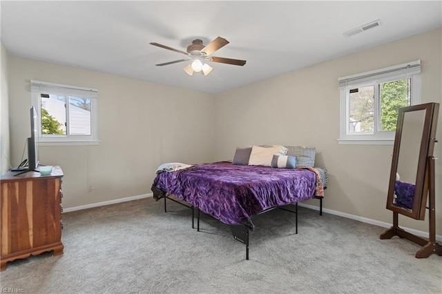 carpeted bedroom featuring visible vents, baseboards, and ceiling fan