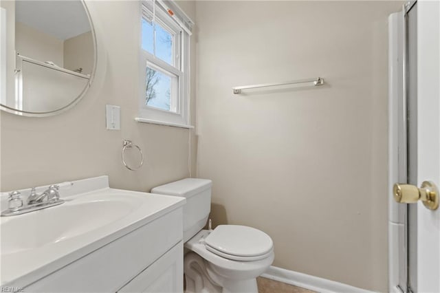 bathroom featuring baseboards, toilet, and vanity