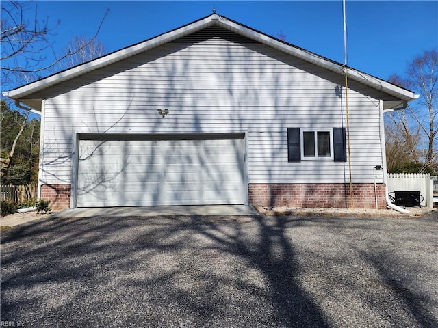 view of home's exterior featuring aphalt driveway, fence, and a garage