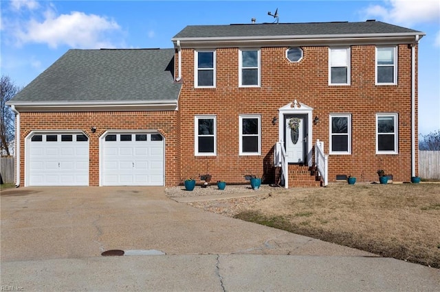 colonial-style house featuring brick siding, driveway, and an attached garage