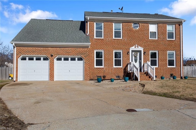 colonial-style house featuring a garage, brick siding, driveway, and fence