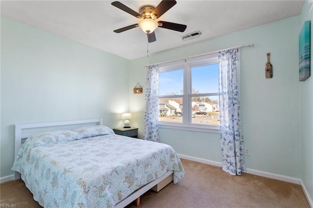 carpeted bedroom with visible vents, ceiling fan, and baseboards