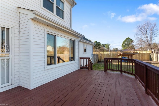 wooden terrace with a fenced backyard