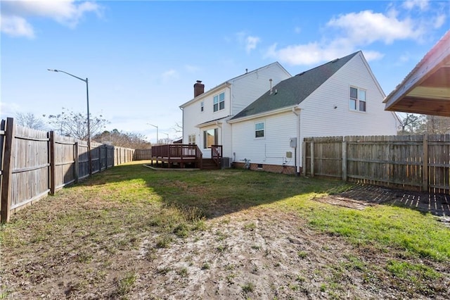 back of property with crawl space, a wooden deck, a yard, and a fenced backyard