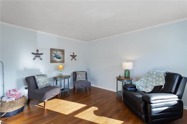 living area with baseboards, wood finished floors, and crown molding