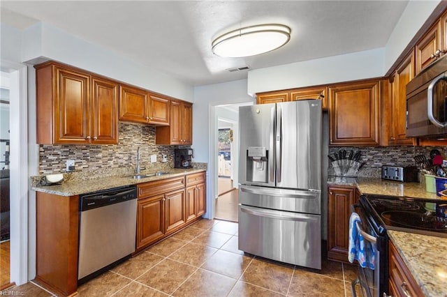 kitchen with visible vents, stainless steel appliances, decorative backsplash, and a sink