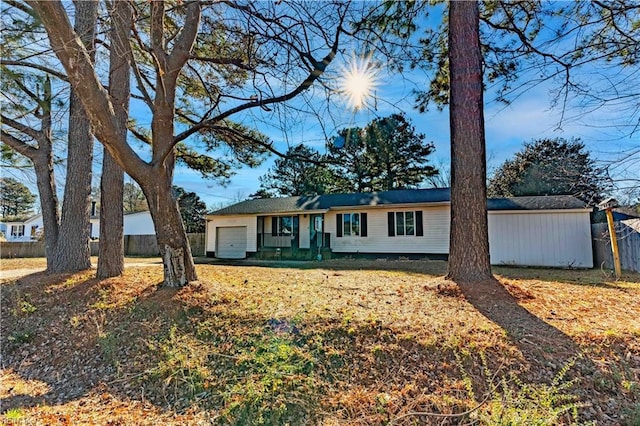 ranch-style house with an attached garage and fence