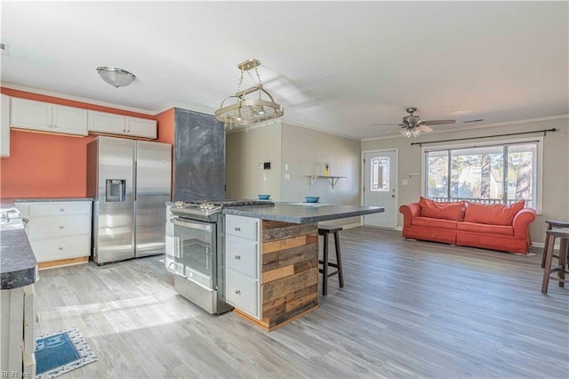 kitchen with stainless steel appliances, light wood-style flooring, crown molding, and white cabinetry