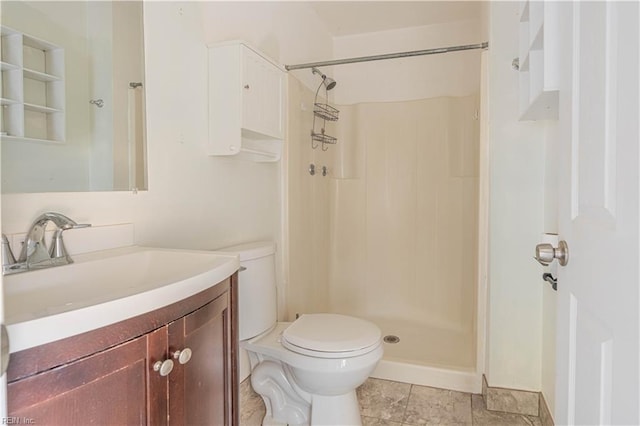 bathroom featuring toilet, a stall shower, and vanity