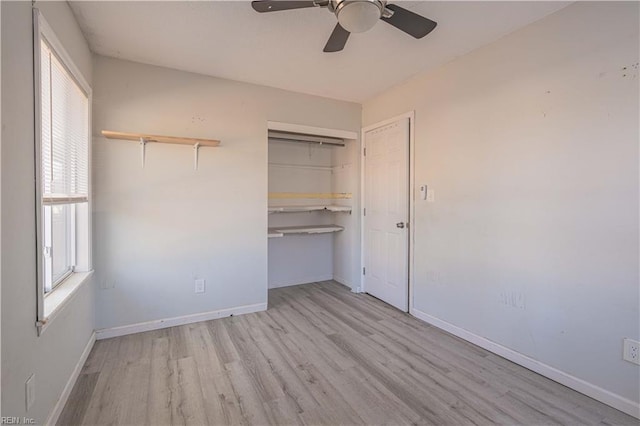 unfurnished bedroom with a closet, baseboards, wood finished floors, and a ceiling fan