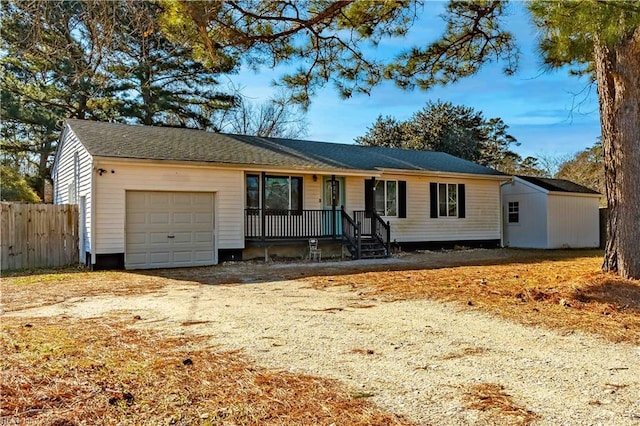 ranch-style house featuring a garage, dirt driveway, and fence