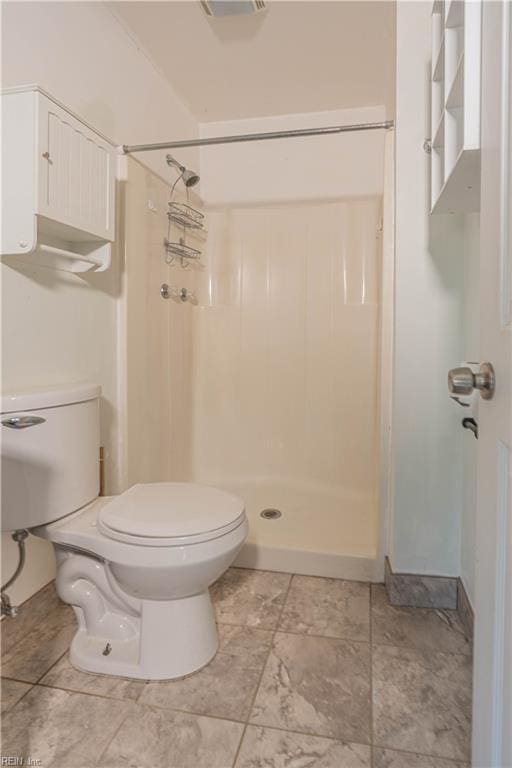 bathroom featuring a shower stall and toilet