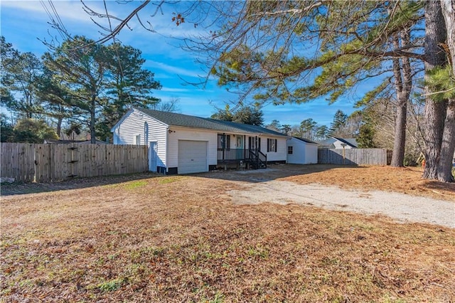 single story home with fence, a garage, and dirt driveway