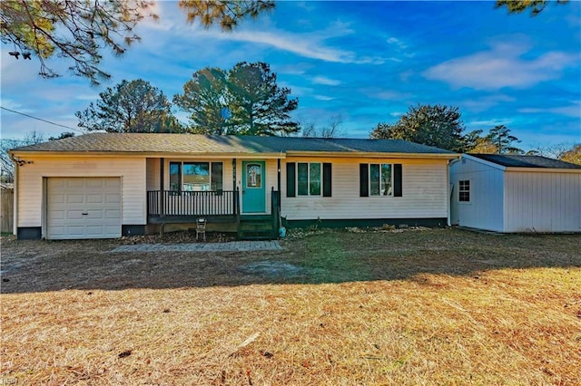 single story home featuring a porch, a front yard, a storage shed, and a garage