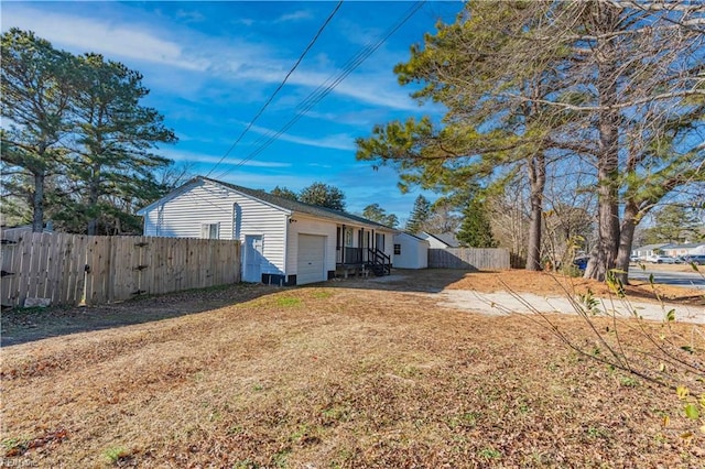 exterior space featuring driveway, a garage, and fence