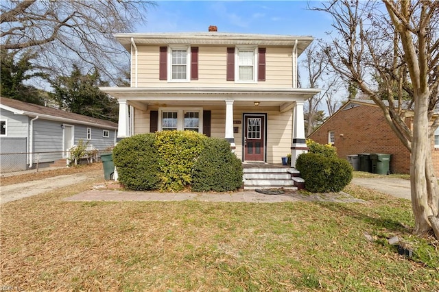 traditional style home featuring a porch and a front yard