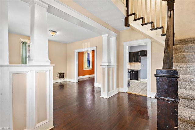 interior space with stairway, baseboards, ornate columns, and hardwood / wood-style flooring