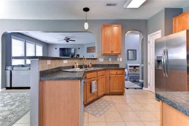 kitchen featuring visible vents, arched walkways, ceiling fan, stainless steel appliances, and dark countertops