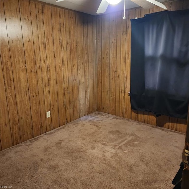 spare room featuring wooden walls and carpet flooring