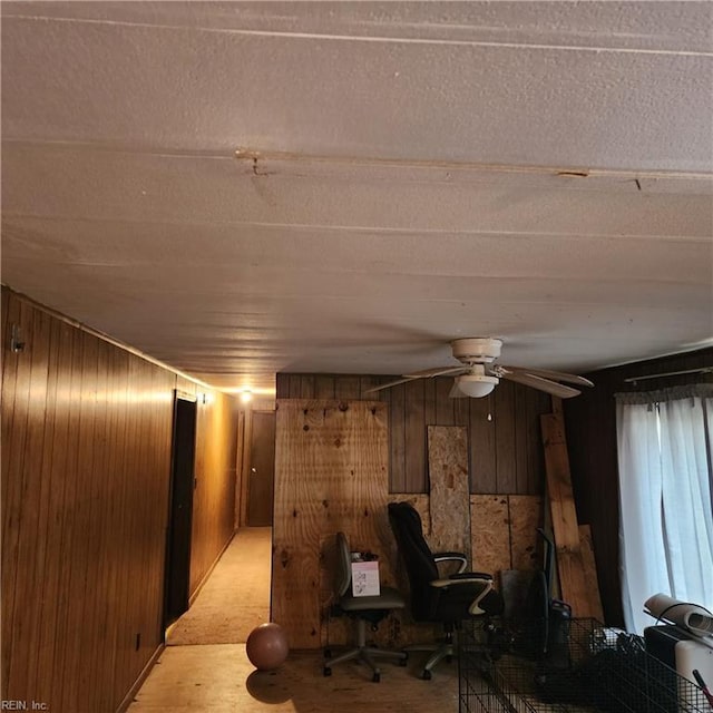 interior space featuring wood walls and ceiling fan