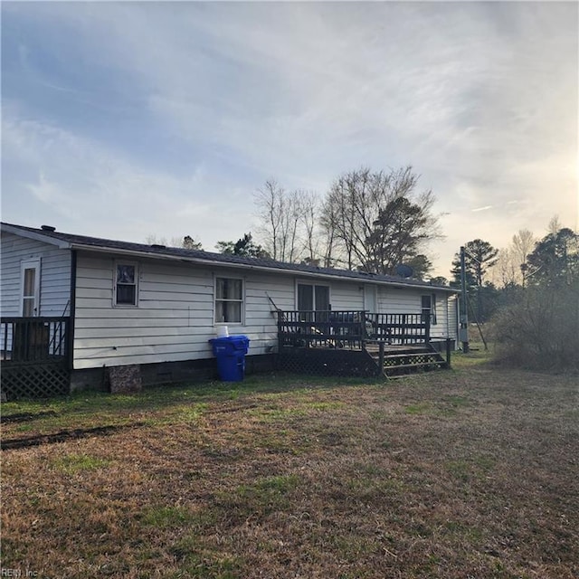 back of property featuring crawl space, a lawn, and a deck